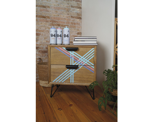 Holzkommode mit geometrischem Muster, Sprühdosen und Büchern