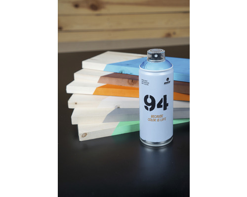 Une bombe de peinture Montana 94 à côté de planches de bois peintes