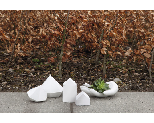 Dekorative Betonobjekte und Pflanzgefäß in Form einer Hand im Garten