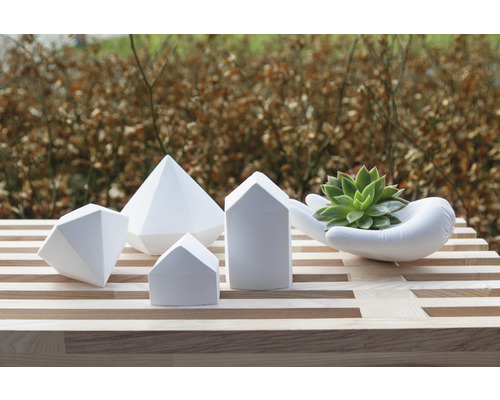 Dekorative geometrische Formen und Handförmiger Übertopf mit Sukkulente auf einem Tisch