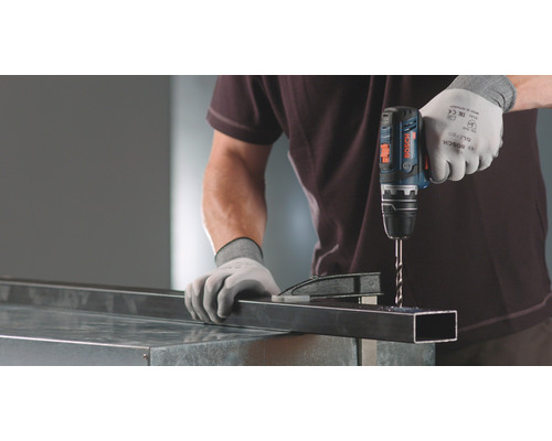 Perceuse-visseuse sans fil perçant un profilé métallique avec des gants.