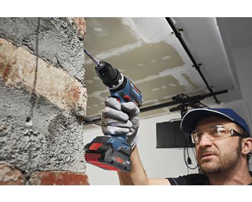 Perceuse en utilisation sur un mur de briques