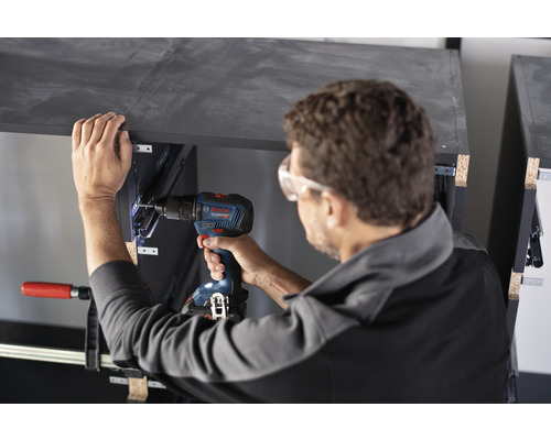 Artisan travaillant avec un tournevis sans fil sur un meuble