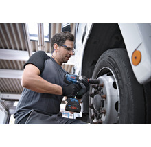 Ein Mann verwendet einen Akku-Drehschlagschrauber, um ein Rad an einem Fahrzeug zu befestigen.