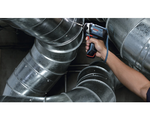 Une visseuse à percussion sans fil perce un tuyau de ventilation. Logo Bosch.