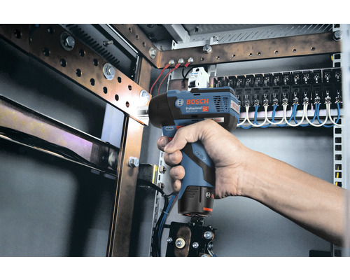 Une main tient une visseuse à chocs sans fil Bosch devant une installation électrique.