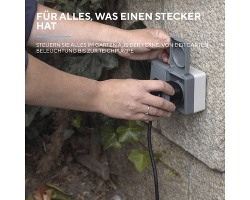 Person steckt Stecker in eine wetterfeste Aussensteckdose
