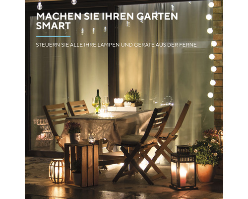 Beleuchteter Gartentisch mit Stühlen und Dekorationsartikeln