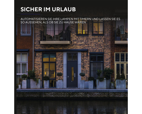 Hausfassade mit beleuchteten Fenstern und Haustür zur Illustration von Zeitschaltuhren für Lampen zur Urlaubssicherung
