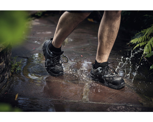 Personne marchant dans une flaque d''eau avec des chaussures de sécurité