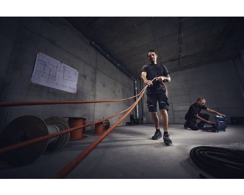 Électriciens tirant des câbles dans un bâtiment en construction
