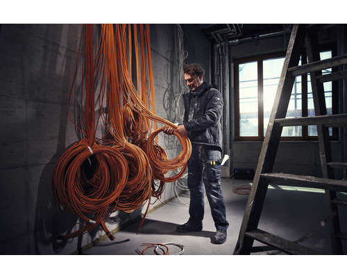 Électricien avec des câbles dans un chantier