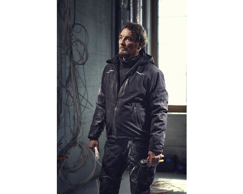 Un artisan porte des vêtements de travail avec une veste et un pantalon.