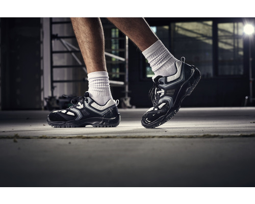 Un homme porte des chaussures de travail dans un intérieur.
