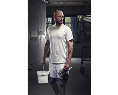 Artisan avec spatule et seau de peinture sur un chantier