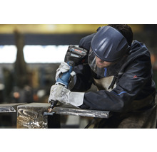 Metallbearbeiter mit Akku-Blechknabber bearbeitet Metall