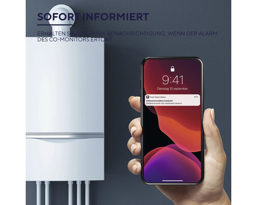 Kohlenmonoxidmelder mit Smartphone-Benachrichtigung neben einer Heizungsanlage