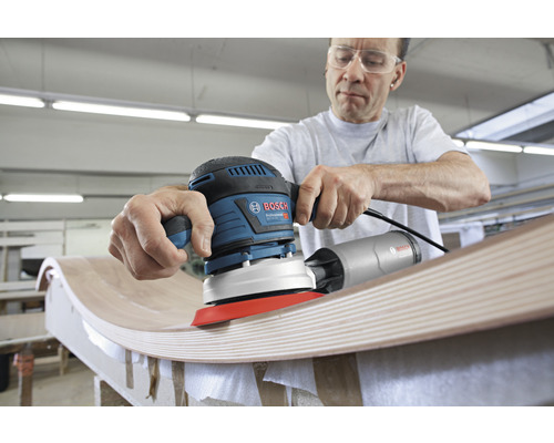 Mann schleift Holz mit einem Exzenterschleifer von Bosch