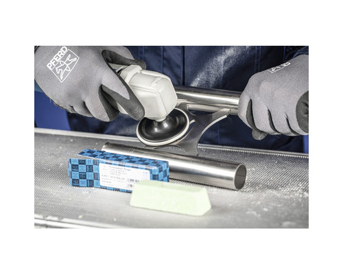 Une personne polit un tube métallique avec une polisseuse, de la pâte à polir et des gants.