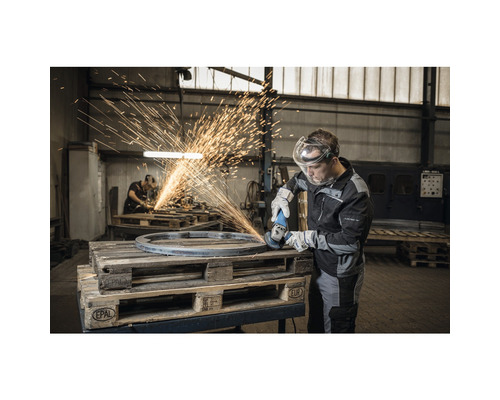 Mann schleift Metall mit Winkelschleifer und Funkenflug