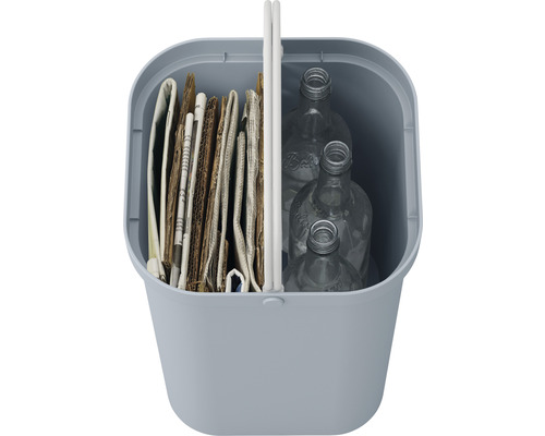 Poubelle remplie de vieux papiers et de bouteilles en verre vides