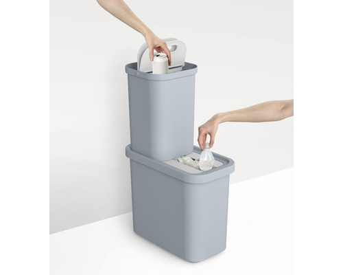 Deux poubelles bleues pour le tri des déchets avec des objets en main jetés dans les poubelles