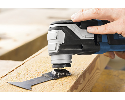 Outil électrique oscillant en train de scier une pièce de bois