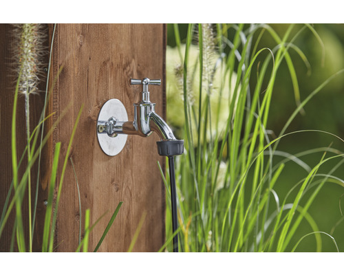 Gartenzapfstelle mit Wasserhahn und Schlauchanschluss an einer Holzwand