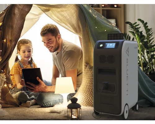 Vater und Tochter mit Tablet in einem Zelt im Haus, daneben eine mobile Bluetti Powerstation