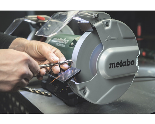 Mann schärft Bohrer mit Schleifmaschine von Metabo