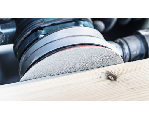 Gros plan d''une ponceuse excentrique ponçant une pièce de bois.