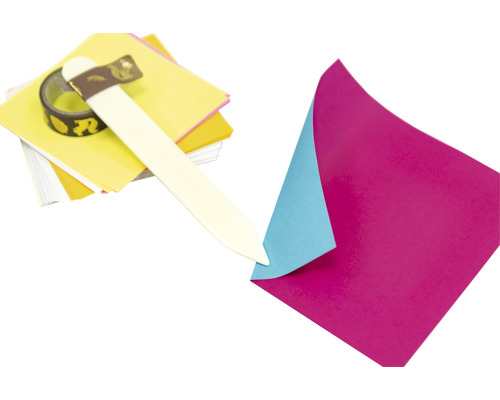 Matériel de bricolage avec du papier, un plioir et du ruban décoratif