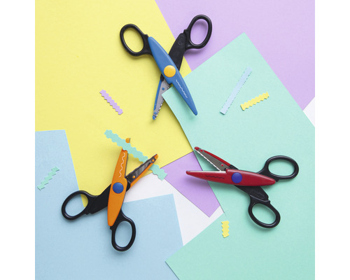 Trois ciseaux décoratifs sur du papier de couleur