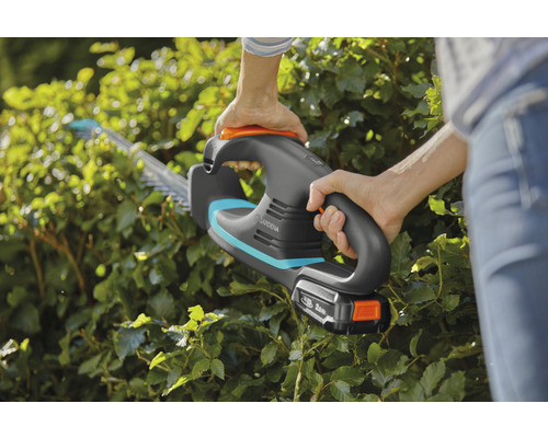 Eine Person schneidet mit einer Gardena Akku-Heckenschere eine Hecke.