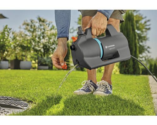 Pompe de jardin en train de pomper l''eau dans le jardin