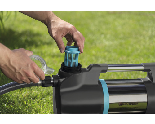 Eine Person setzt einen Filter in eine Gartenpumpe ein.