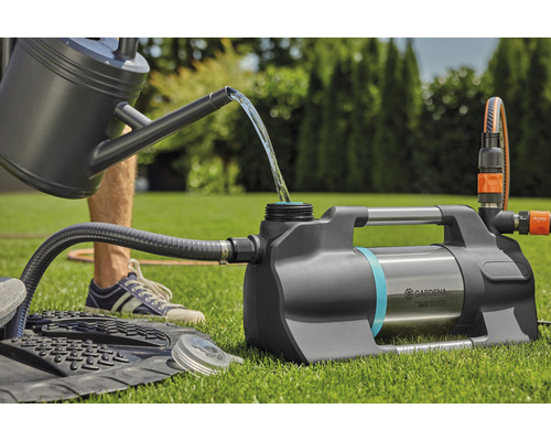Gardena Hauswasserautomat mit Gießkanne und Schlauch auf Rasen