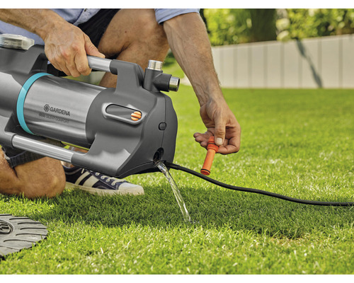 Person bedient Gardena Gartenpumpe 6500 SilentComfort auf Rasen