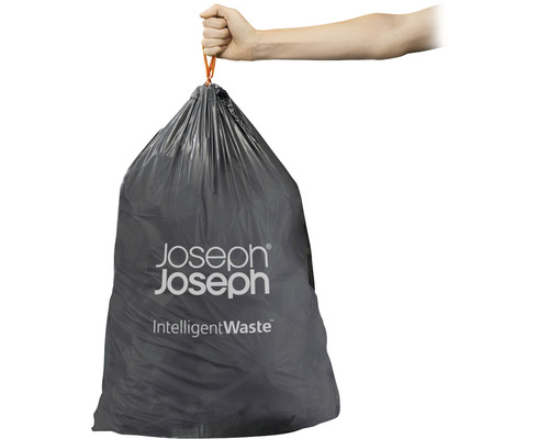Eine Hand hält einen vollen grauen Müllbeutel mit Zugband der Marke Joseph Joseph.