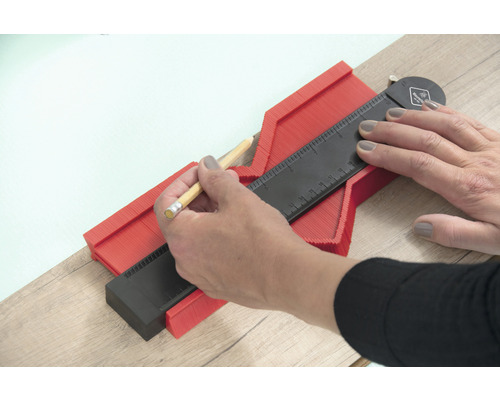 Eine Person benutzt eine Konturlehre zum Übertragen von Formen.