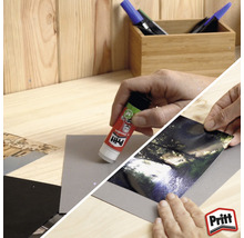 Personne collant une photo sur du papier avec un bâton de colle