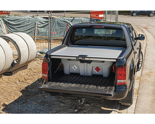 Pickup mit Gefahrgutbehälter auf einer Baustelle