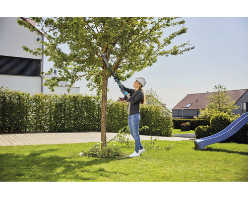 Frau mit Astschere bei der Baumpflege im Garten.
