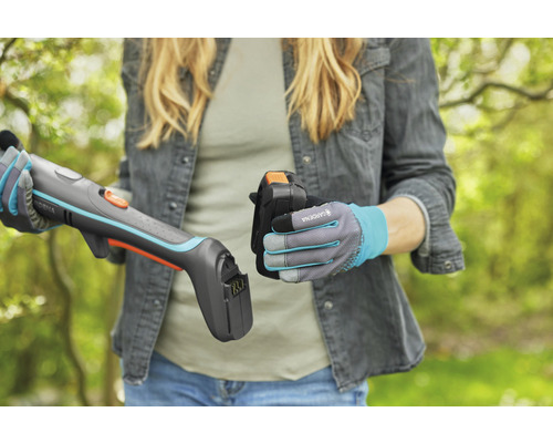 Frau setzt Akku in eine Gardena Akku-Grasschere ein