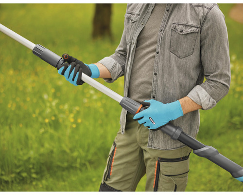 Une personne portant des gants de jardinage tient une rallonge de manche télescopique à l''extérieur.