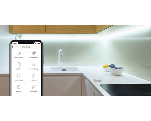 Smartphone mit einer App zur Steuerung von LED-Streifen in einer modernen Küche.