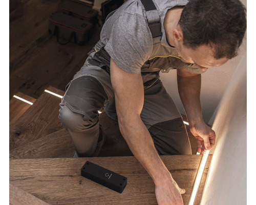 Handwerker installiert LED-Treppenbeleuchtung in einem Treppenhaus.