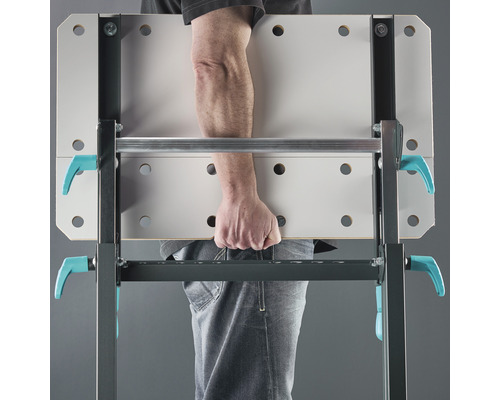 Une personne transporte un établi.