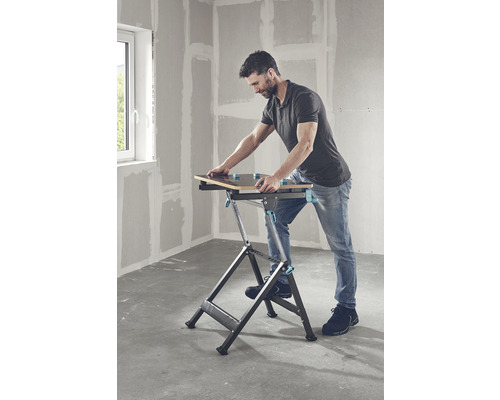 Un homme utilise un établi pliable dans une pièce.