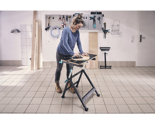Femme travaillant sur un établi avec des outils au mur